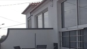 An outdoor patio with a table and chairs, a tiled floor, and a railing. - VILLA IN THE CENTER OF FUNCHAL WITH STUNNING VIEWS OVER THE BAY (Funchal)