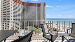 Ein Balkon mit Blick auf einen Strand und ein Hotelgebäude.