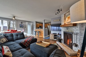 Una sala de estar moderna con chimenea, un comedor y una cocina.