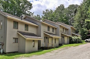 A row of single-story mobile homes with a simple design, each featuring a front porch and a small attached garage. - Hemlock Ridge 2b: Charming Two Floor Condo In The Heart Of Killington. Perfect! 3 Bedroom Condo (Killington)