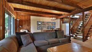A cozy living room with a wooden ceiling, a large sectional sofa, a wooden coffee table, and a staircase leading to an upper level. - Hemlock Ridge 2b: Charming Two Floor Condo In The Heart Of Killington. Perfect! 3 Bedroom Condo (Killington)