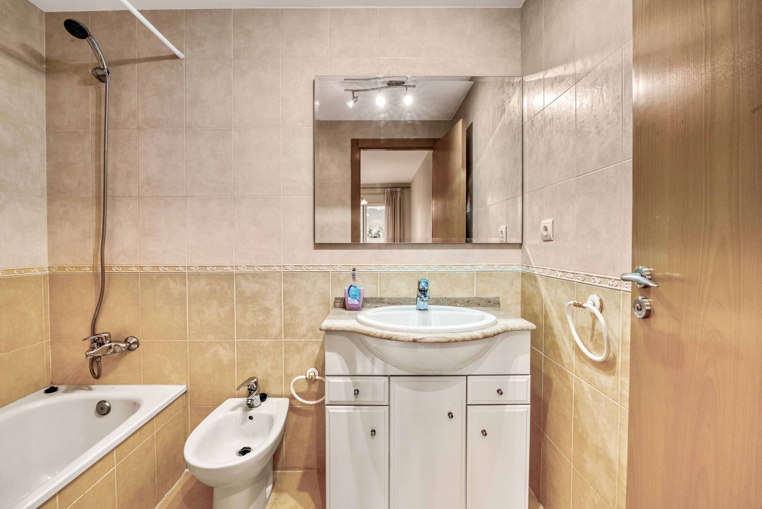 A bathroom with a bathtub, a sink, a bidet, and a shower.