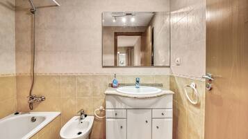 A bathroom with a bathtub, a sink, a bidet, and a shower.