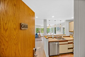 A modern kitchen with a dishwasher, wooden cabinets, and pendant lighting. - Fall Line Condos by Killington VR - 3 Bedrooms (Killington)