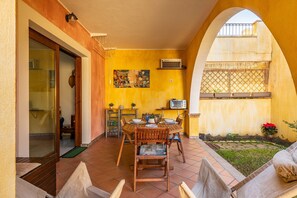 A dining area with a table, chairs, and a TV. - Holiday Home 'Casa Celeste' with Shared Pool, Private Terrace and Air Conditioning (Villasimius)