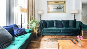 A living room with a green sofa, a wooden coffee table, and a framed picture on the wall. - OYO The Lodge Bournemouth (Bournemouth)
