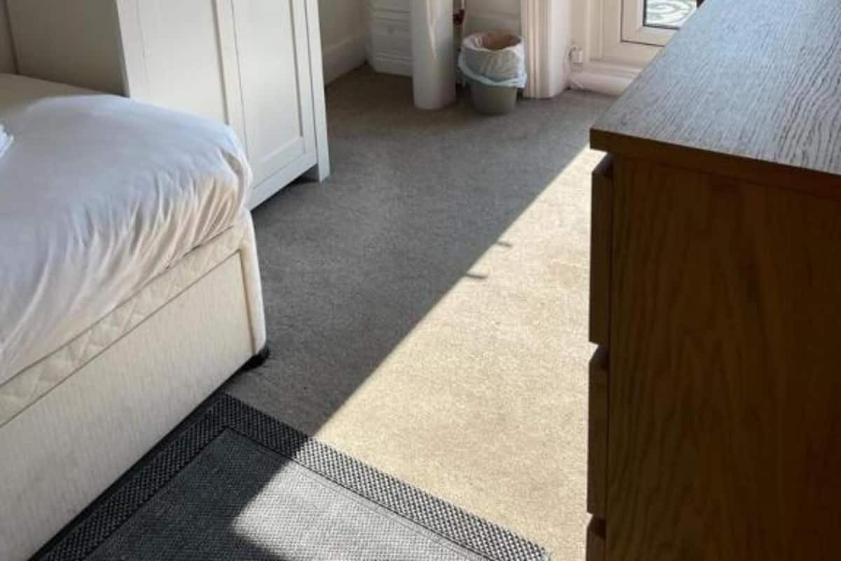 Un dormitorio con cama, armario, lavabo y ventana con vistas a árboles.