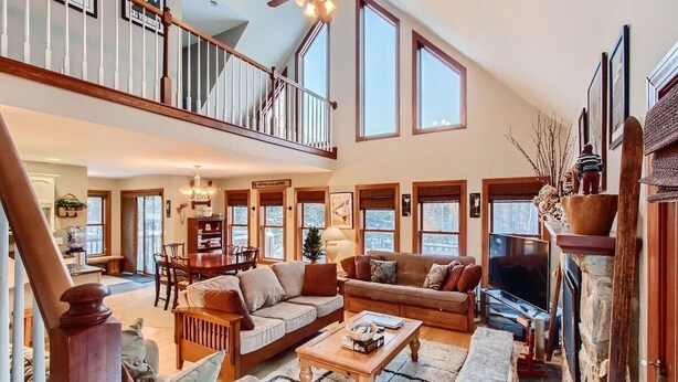 A spacious living room with a high ceiling, a fireplace, and a television. - Cortina Mountain Chalet - Outdoor Hot Tub - Close To Pico And Killington Mountains 3 Bedroom Home (Rutland)