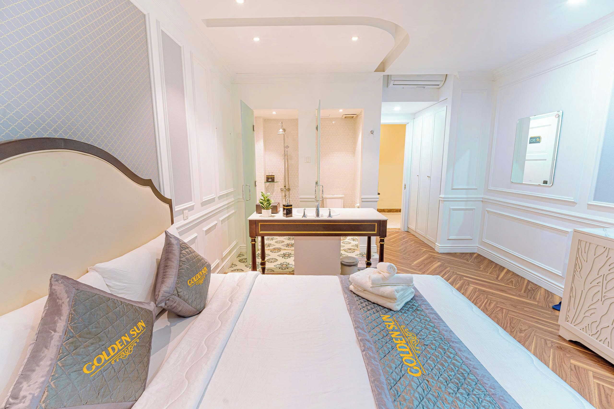 A hotel room with a bed, a vanity with a mirror, and a bathroom visible through an open door.