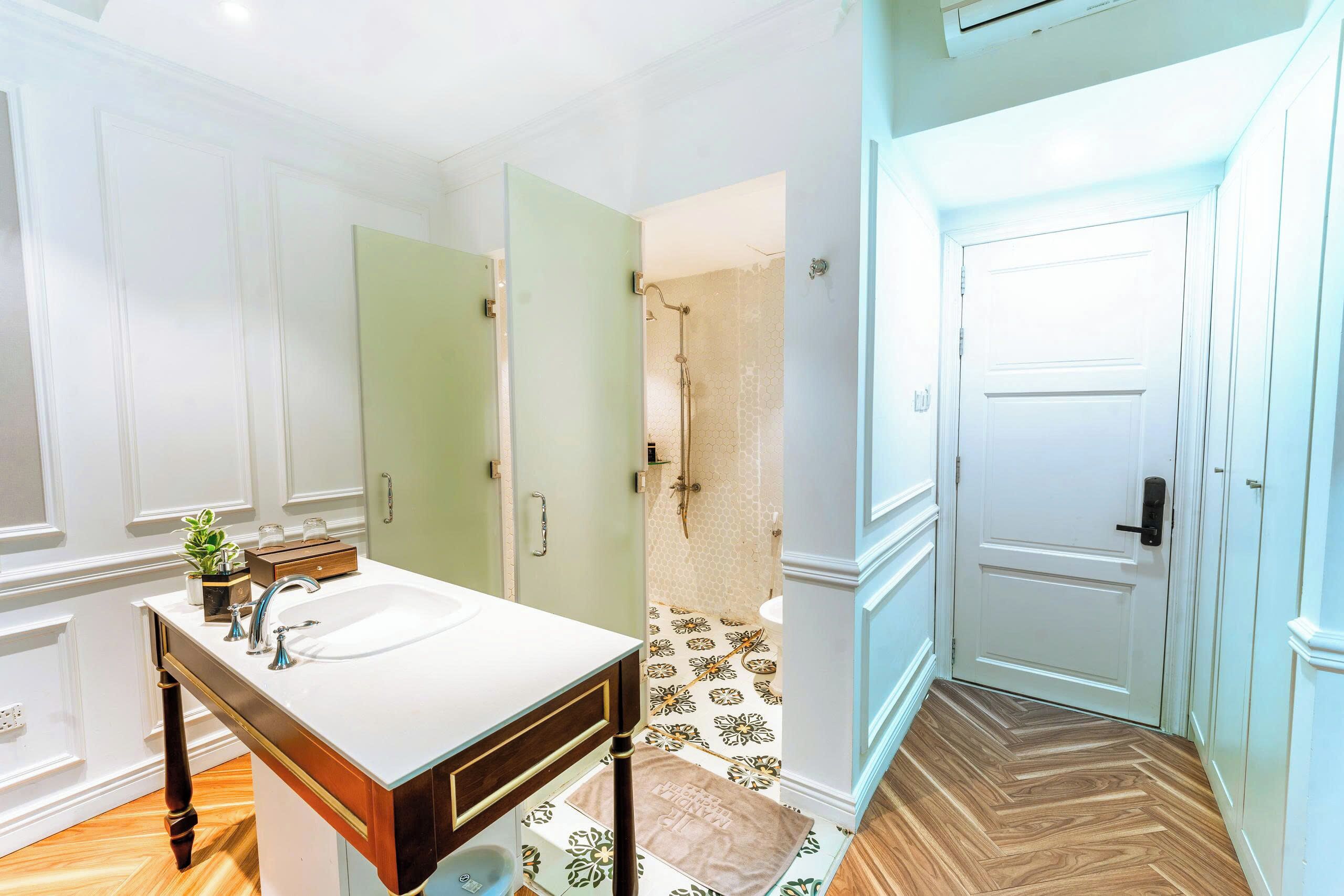 Une salle de bain avec un meuble-lavabo en bois, un évier et un espace douche.