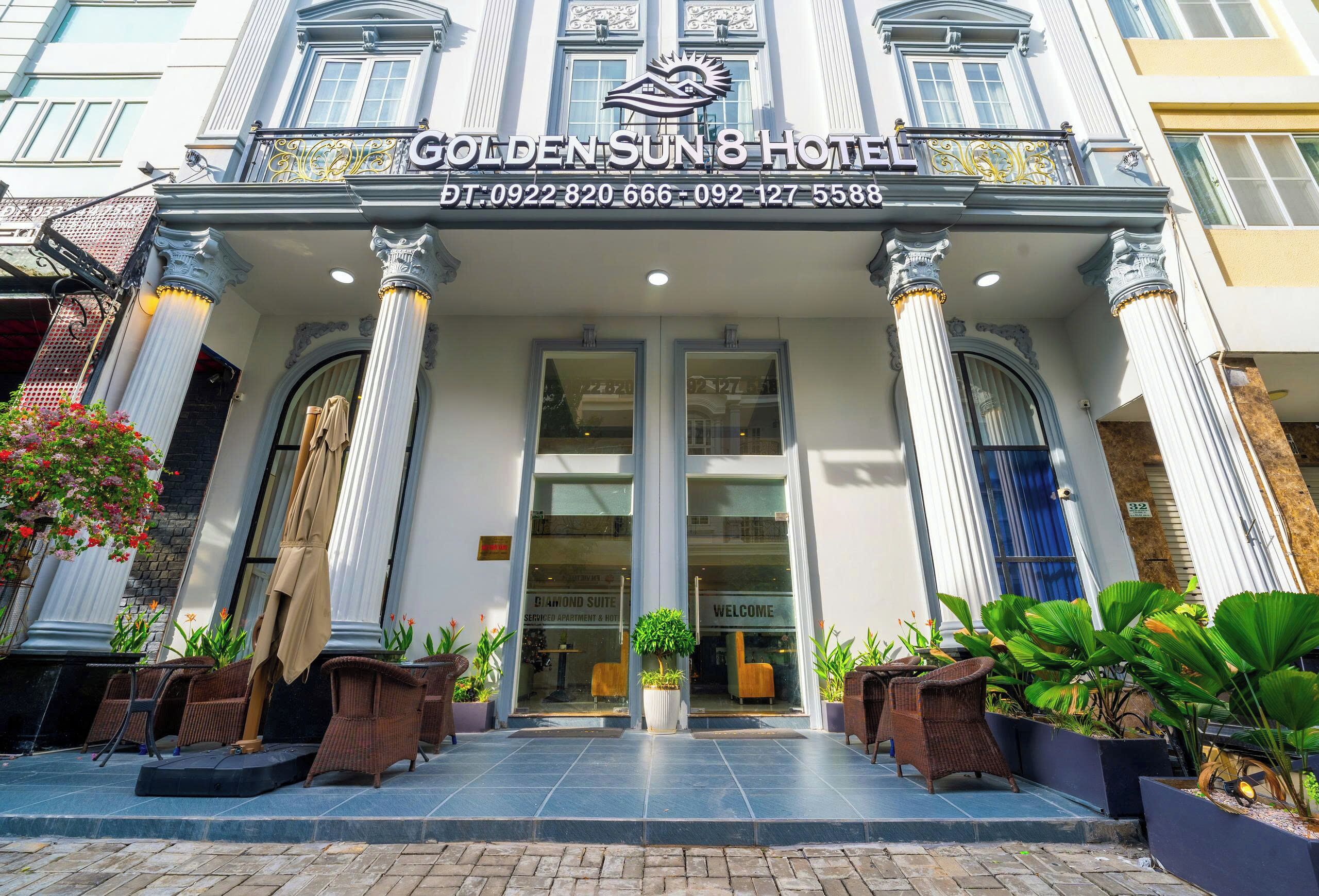 Exterior del Hotel Golden Sun 8 con un diseño arquitectónico clásico, con columnas, una entrada acogedora y plantas en macetas.
