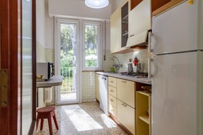 Una cocina equipada con estufa a gas, lavavajillas y refrigerador.