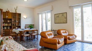 Una sala de estar con comedor, chimenea y un ventanal grande.
