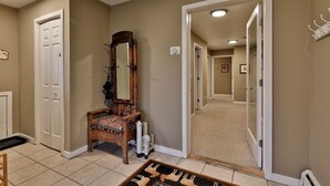 A hallway with a wooden bench, a mirror, and a door leading to another room. - The Tanglewood Lodge: Amazing Ski Home For Groups. Hot Tub. Close To Killington Resort! 4 Bedroom Home (Killington)