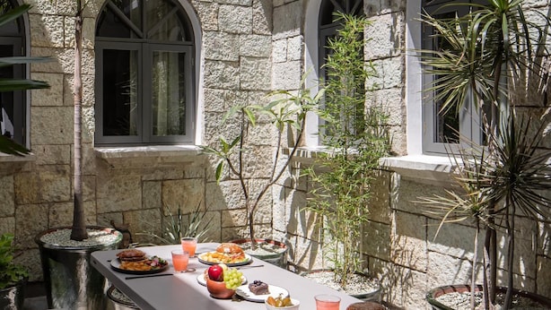A stone building with arched windows and a table set with food and drinks. - Sleeps 9, Outdoor Space, PingPong Table, in Villa (Oaxaca de Juárez)