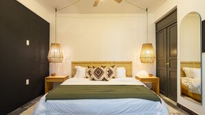 A bedroom with a bed, two bedside lamps, a ceiling fan, a wooden nightstand, a mirror, and a door. - Sleeps 9, Outdoor Space, PingPong Table, in Villa (Oaxaca de Juárez)