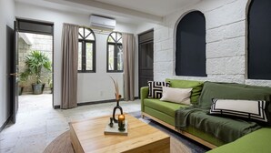 A modern living room with a green sofa, a wooden coffee table, and a potted plant. - Sleeps 9, Outdoor Space, PingPong Table, in Villa (Oaxaca de Juárez)