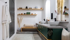 A modern bathroom with a large mirror, a sink, and a vanity. There are shelves with decorative items and a towel rack. - Sleeps 9, Outdoor Space, PingPong Table, in Villa (Oaxaca de Juárez)