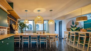 Une cuisine moderne dotée d’un îlot central, de luminaires suspendus et offrant une vue sur la ville.