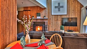 Una habitación acogedora con chimenea, televisión y comedor listo para una comida.