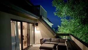 Un patio exterior con un sofá, un tapete estampado y una lámpara.