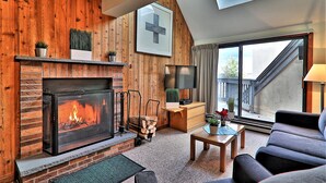 Una sala de estar acogedora con chimenea, televisor y asientos cómodos.