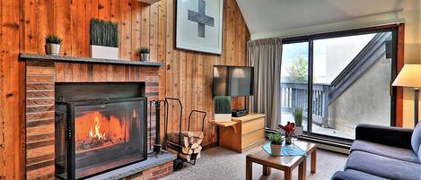 A cozy living room with a fireplace, a television, and comfortable seating.