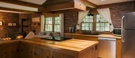 A kitchen with wooden cabinets, a built-in stove, and a large window with curtains.