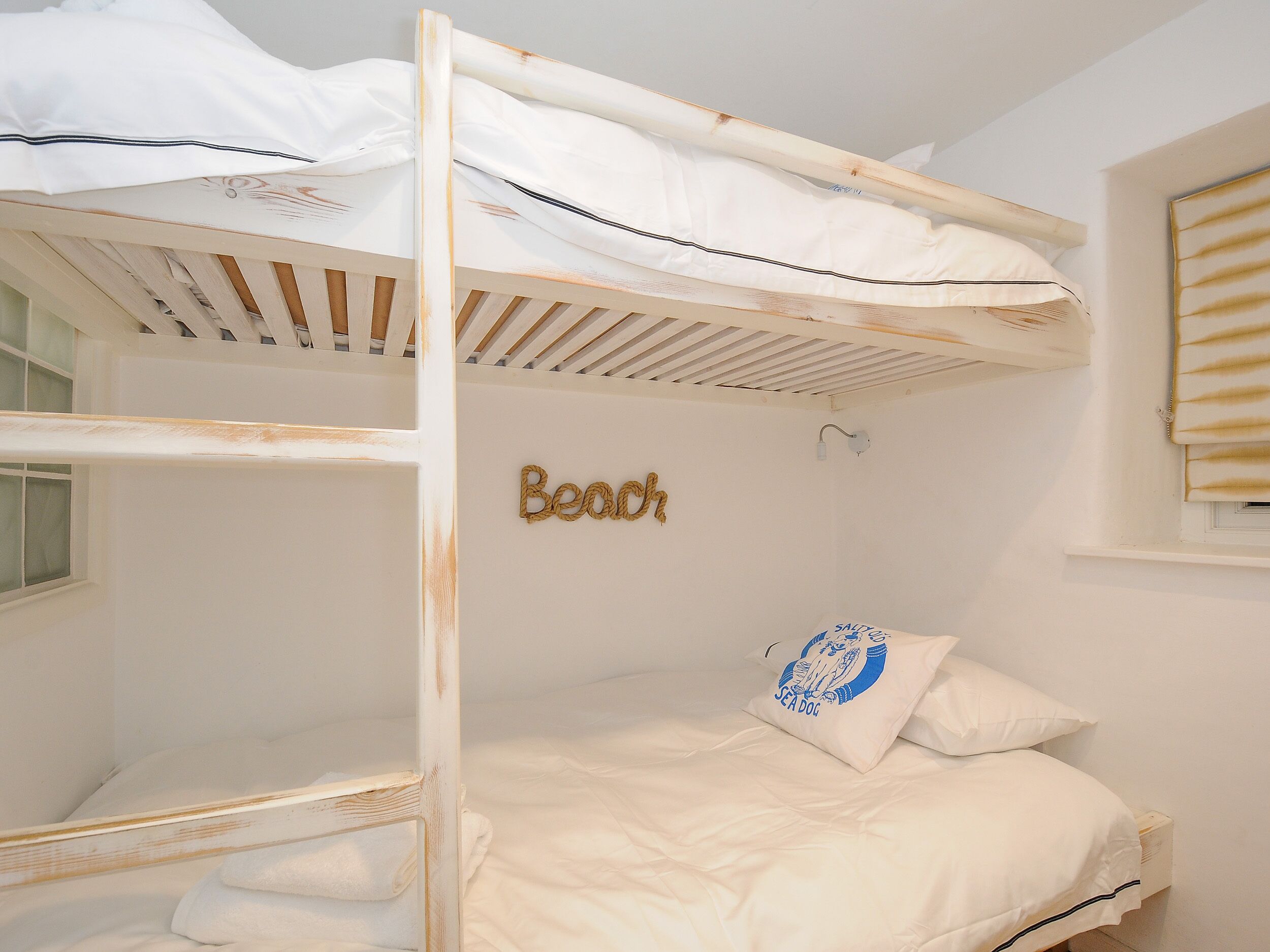Habitación con literas y una placa que dice 'Beau'.