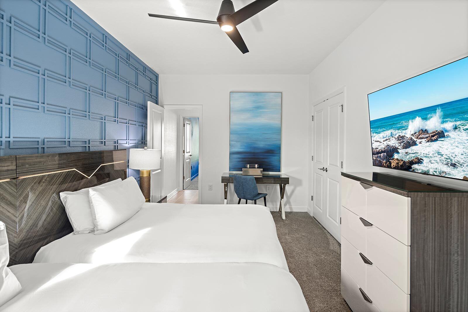 Une chambre d’hôtel avec un grand lit, un bureau, une chaise, une télévision et une vue sur l’océan.