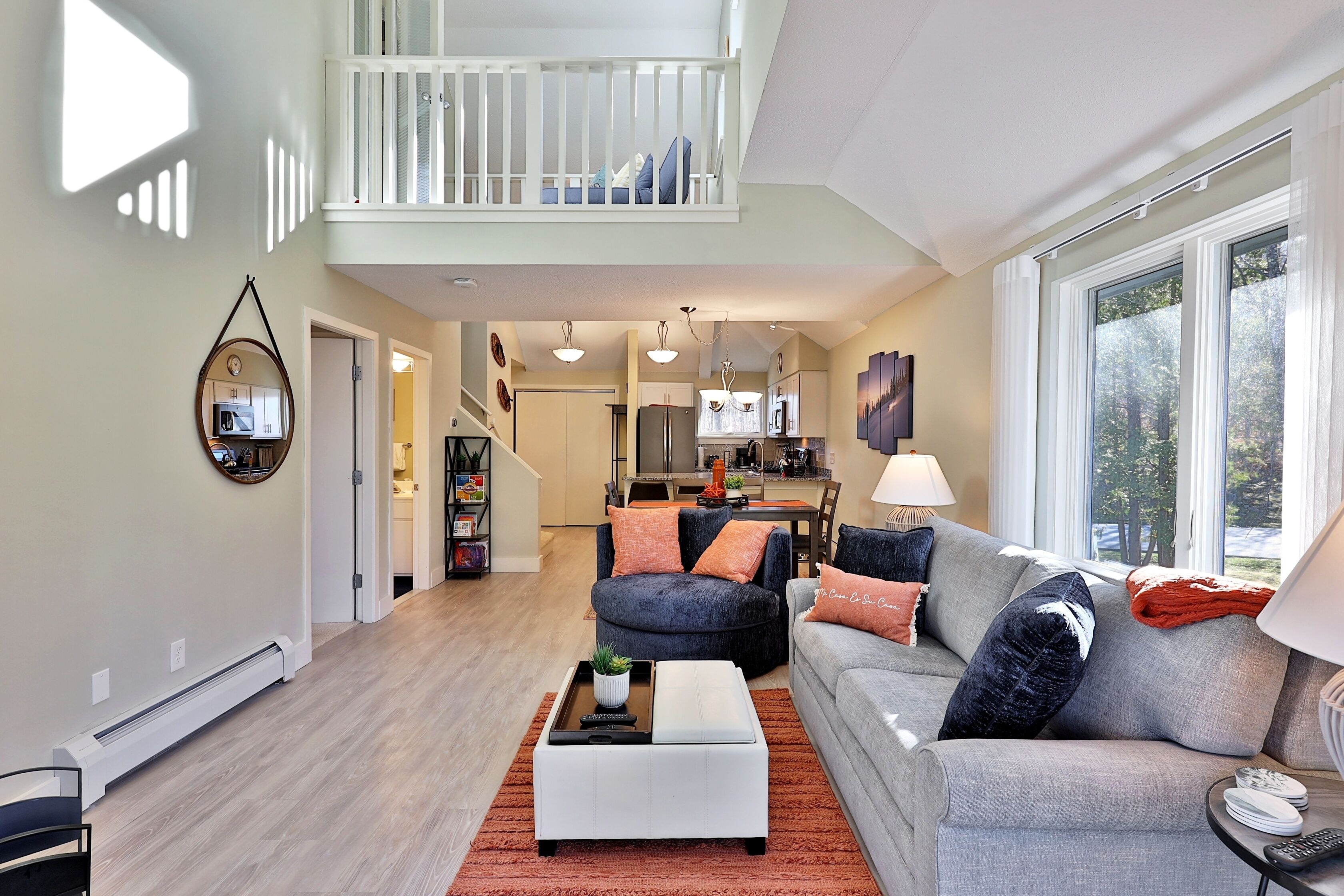A spacious living area with a high ceiling, a dining area, and a kitchen.