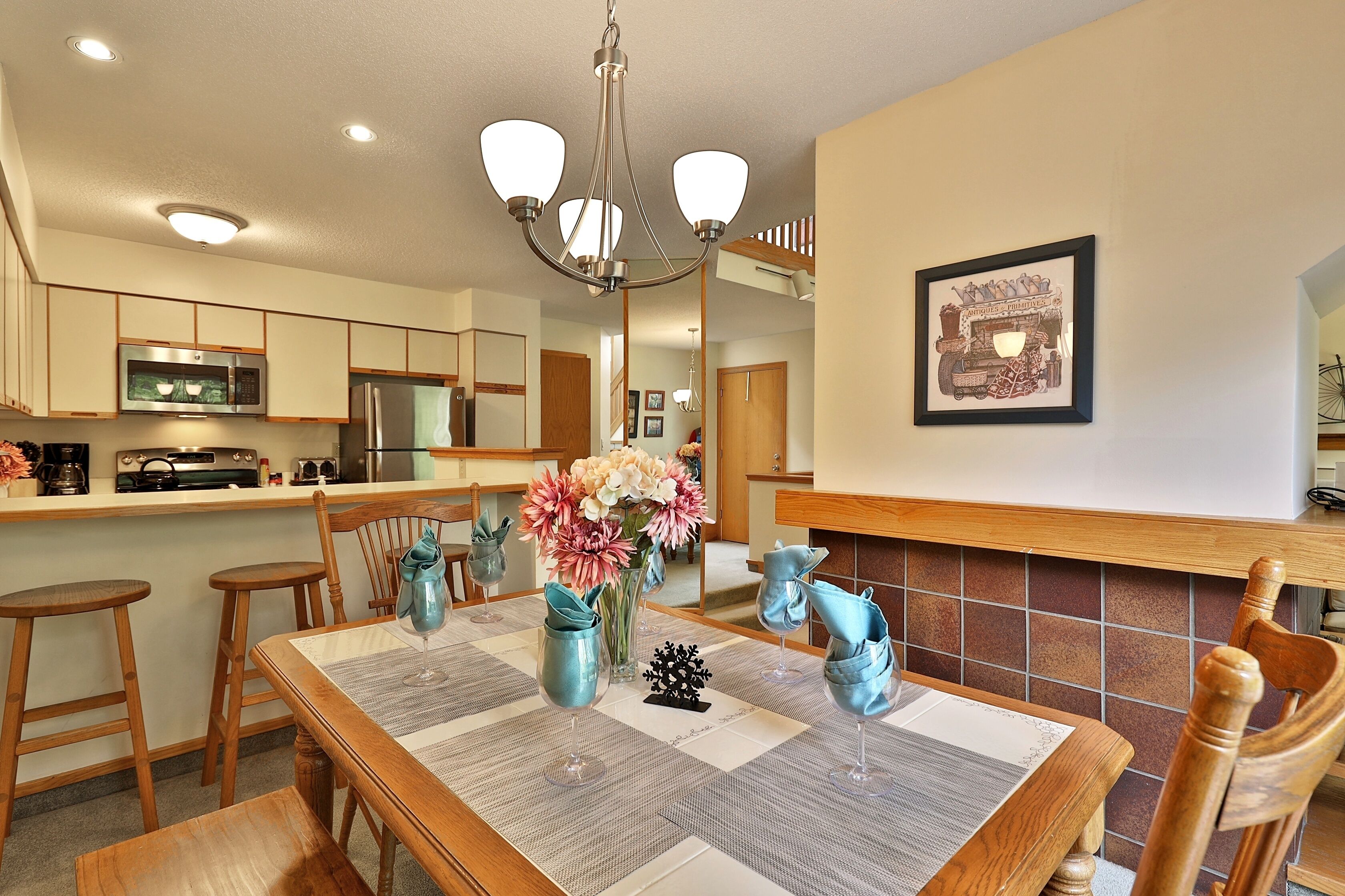 A dining area with a wooden table, chairs, and a chandelier.