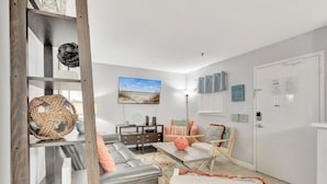 A modern living room with a sofa, coffee table, and decorative items. - Snow Lion On The Beach 2 Bedroom Villa by RedAwning (Hilton Head Island)