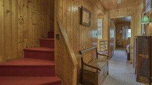 A wooden interior with a staircase, a bench, and a door leading to another room. - Cosy family chalet. Privileged location (La Clusaz)