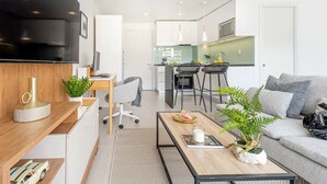 A modern apartment with a living room, dining area, and kitchen. - New apartment in Barrio El Golf (Las Condes)