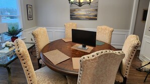 A dining area with a round table, six chairs, a chandelier, and a painting on the wall. - Luxury Home 12 Overnight Guests, Wi-Fi for Online Worker, Theme Gold & Diamonds (Woodstock)