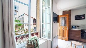 A modern kitchen with a wooden door, a microwave, and a small dining area.