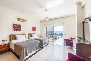 Ein Hotelzimmer mit zwei Betten, einem Balkon mit Pool und Meerblick.