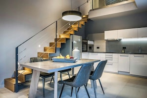 Eine moderne Küche mit weißen Schränken, einem eingebauten Backofen und einem Edelstahl-Kühlschrank.