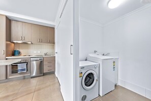 A modern kitchen with stainless steel appliances, a dishwasher, and a built-in oven. - Casa D' Amore' (Airlie Beach)