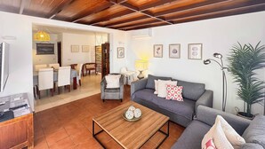 Un salon comprenant un canapé, une table basse et un coin repas avec des chaises et une table.