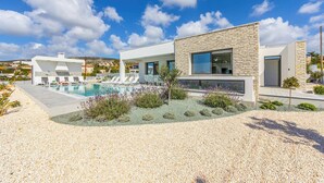 A modern house with a swimming pool, a covered patio, and a well-maintained garden.