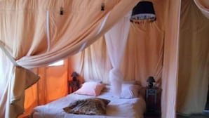 A room with a bed under a canopy, a nightstand, and a lamp. - Lodge l'Immortelle (Zonza)