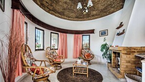 A cozy living room with wicker chairs, a round coffee table, and a fireplace. - Villa Gira - Four Bedroom Villa, Sleeps 8 (Albufeira)