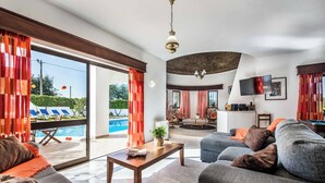 A spacious living area with a pool view, a dining area, and a kitchen. - Villa Gira - Four Bedroom Villa, Sleeps 8 (Albufeira)