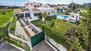 A modern house with a swimming pool, a covered patio, and a well-maintained garden. - Villa Gira - Four Bedroom Villa, Sleeps 8 (Albufeira)