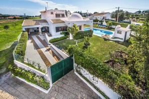 Ein modernes Haus mit Swimmingpool, überdachter Terrasse und gepflegtem Garten.