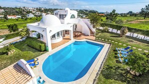 A modern villa with a swimming pool, outdoor seating, and a view of the surrounding landscape. - Villa Gira - Four Bedroom Villa, Sleeps 8 (Albufeira)