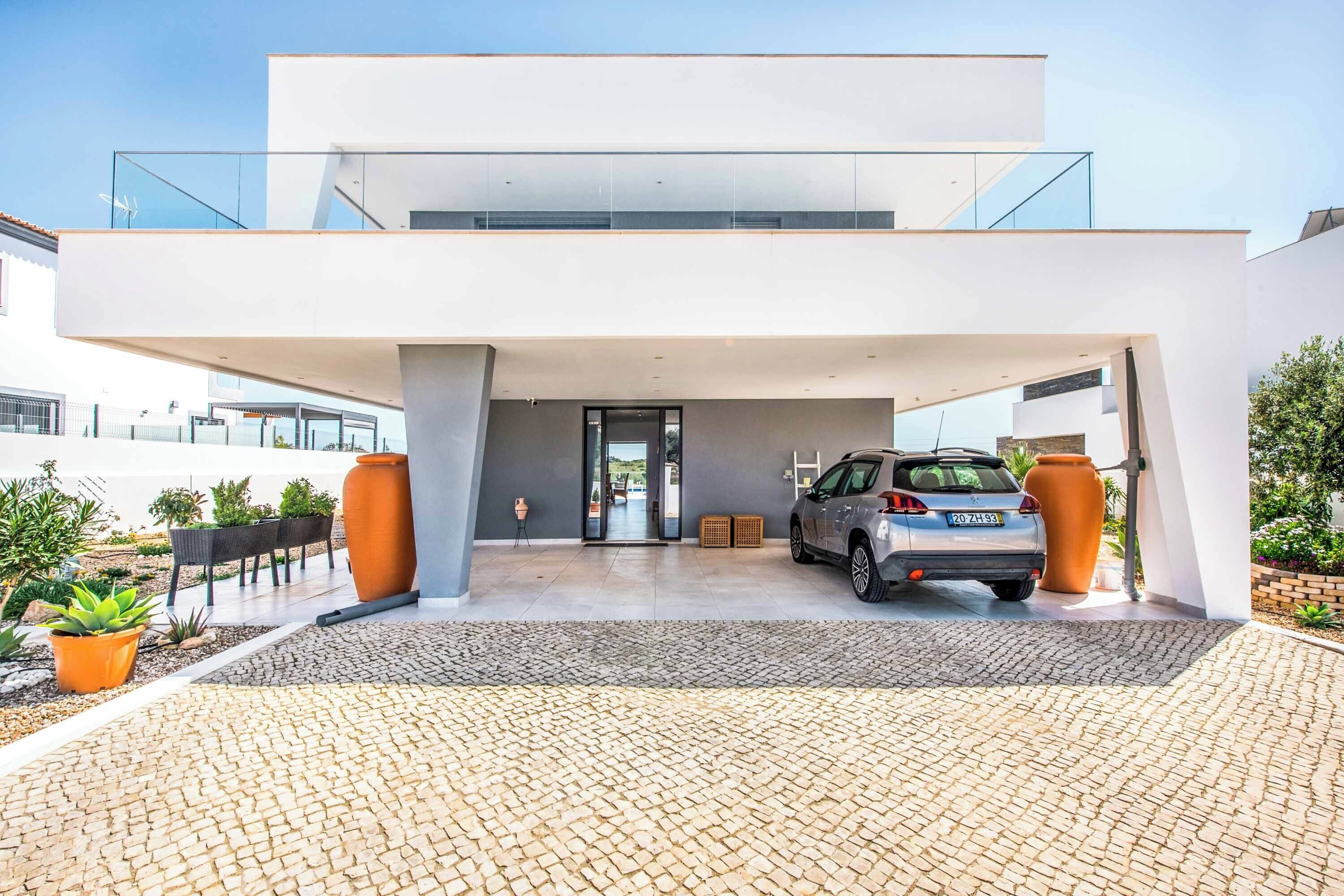 A modern two-story building with a car parked in the driveway.