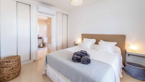 A neatly arranged bedroom with a bed, bedside tables, and a hanging light fixture. - Villa Samui - Four Bedroom Villa, Sleeps 8 (Playa Blanca)